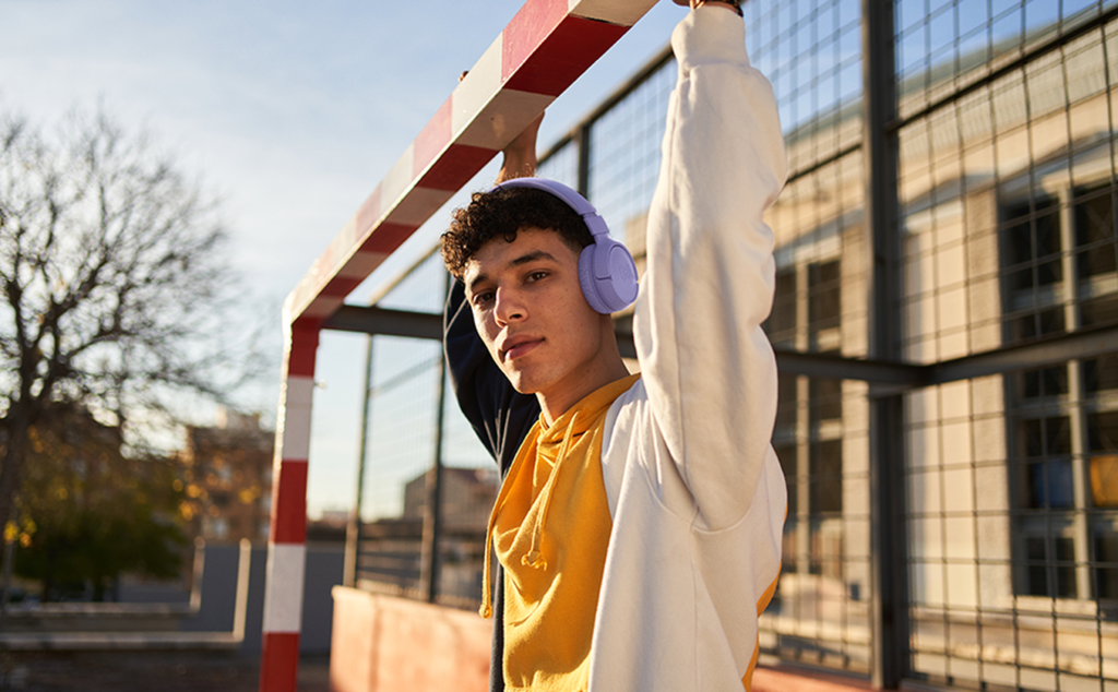 Homem ao ar livre usando o headphone JBL Tune 520BT na cor roxa