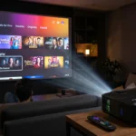 Um homem assistindo à interface do Globoplay projetada em uma grande tela de parede em uma sala de estar escura por um projetor moderno na mesa lateral, com controle remoto e pipoca. Esta imagem exemplifica o sucesso de um tutorial sobre como instalar Globoplay e CazéTV no mini projetor.